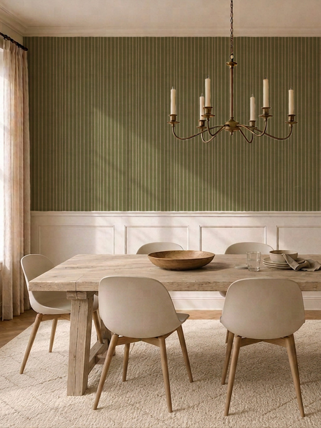 Olive and dusty pink striped wallpaper in elegant dining room with wooden table and chandelier.
