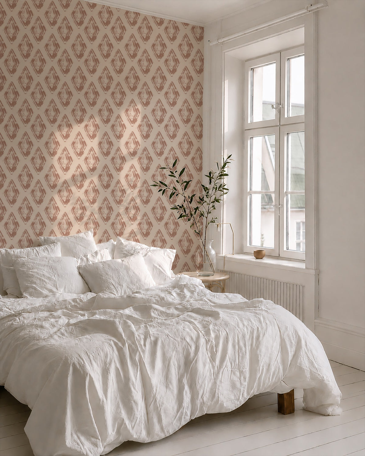 Bedroom with rose clay diamond block print wallpaper and white bedding.