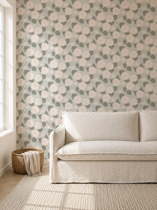 Sage wallpaper with cream dahlia pattern in a cozy living room setting.