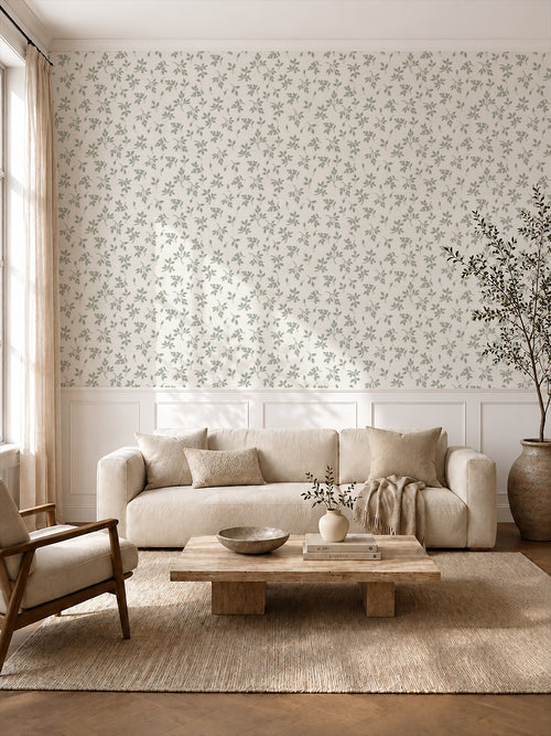 Sage green leaf sprig wallpaper in a cozy living room with natural wood furnishings.